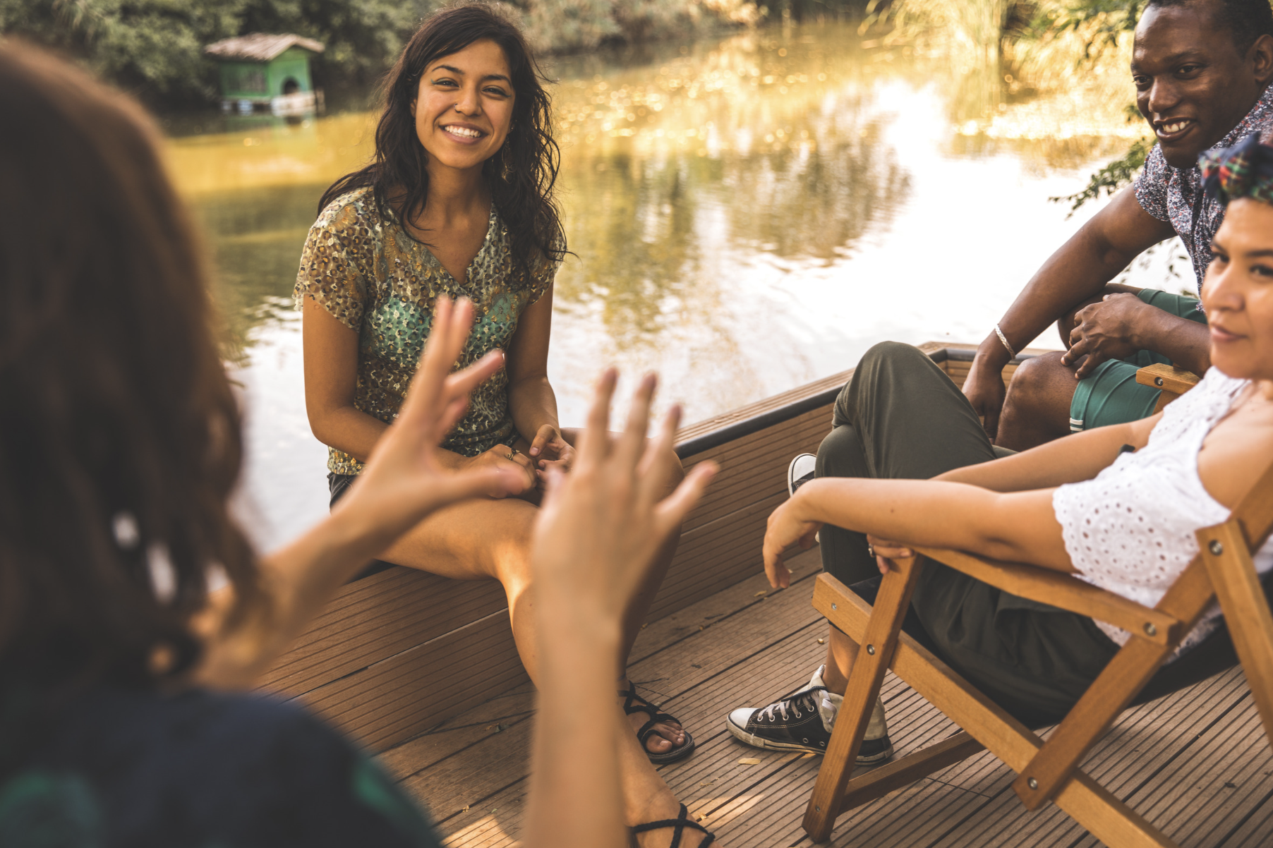 group of 4 individuals smiling and enjoying intercultural communication on the water