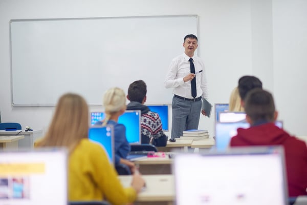 group of students with teacher in computer lab classrom learrning lessons,  get help and support