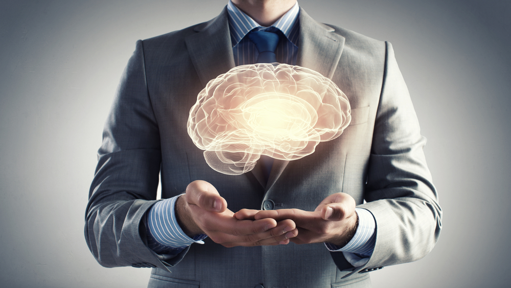Close up of businessman holding digital image of brain in palm to show the power of language programs
