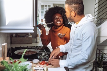 Man and woman cooking together during a virtual language training experience